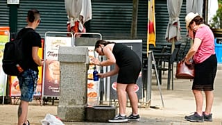 Des madrilènes devant une fontaine publique du parc Retiro, samedi 21 mai 2022.