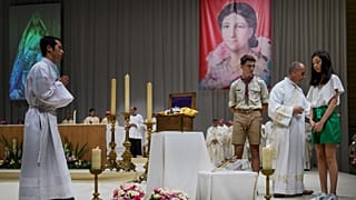 Mayline Tran, 13 ans, médite devant les reliques de Pauline Jaricot lors d'une messe près de Lyon, le 22 mai 2022.