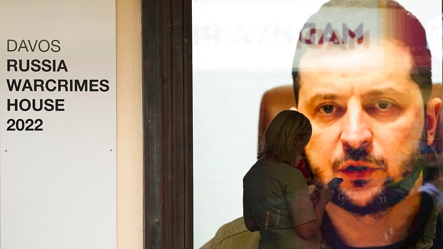 Ukrainian President Volodymyr Zelenskyy speaks on a screen inside a so-called Russian War Crimes House alongside the World Economy Forum in Davos, Switzerland, Sunday