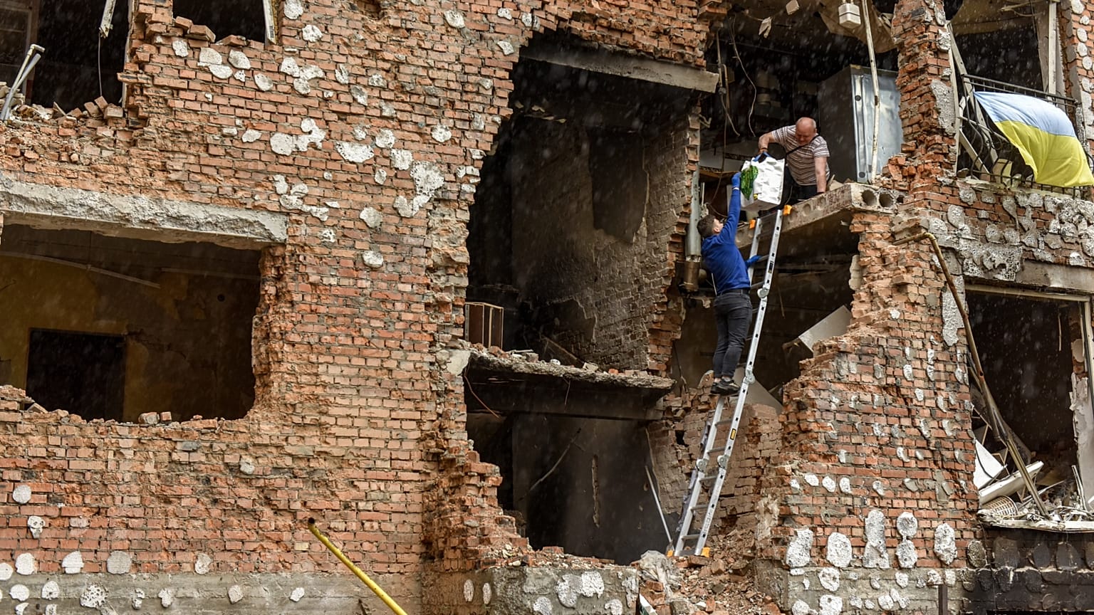 Lerombolt lakóházukból menekítenek ki tárgyakat emberek a Kijev melletti Irpinyben