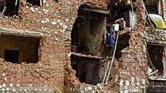 Lerombolt lakóházukból menekítenek ki tárgyakat emberek a Kijev melletti Irpinyben