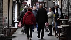 Menschen bummeln durch die Markthalle von Butscha nahe Kiew