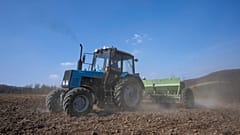 Workers plow wheat on the land belonging to Vasyl Pidhaniak, in Husakiv village, western Ukraine, Saturday, March 26, 2022.