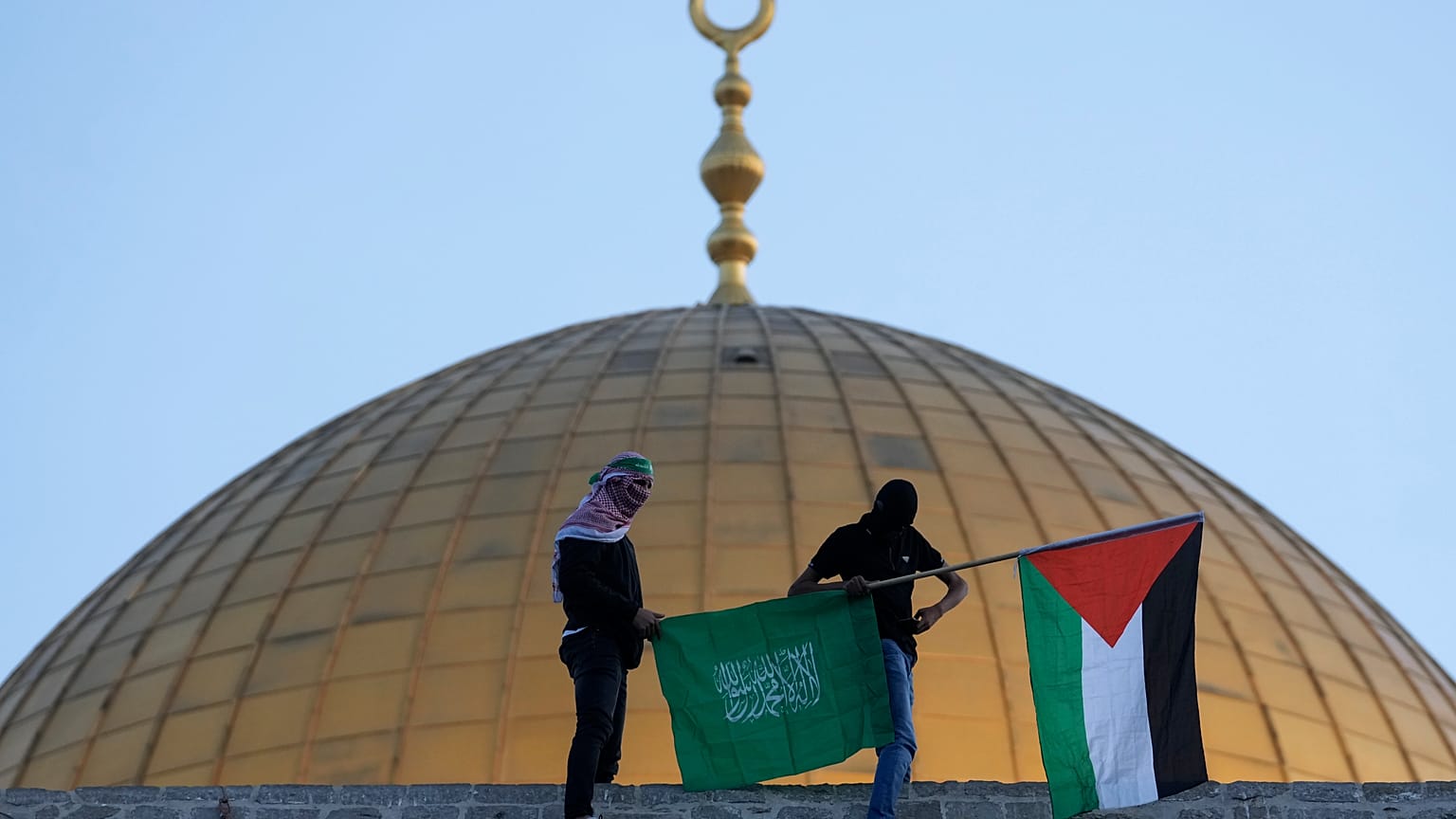 صورة لشخصين يحملان علمي فلسطين والسعودية بالقرب من المسجد الأقصى