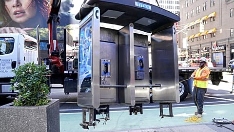 Workers remove the final New York City payphone in Midtown Manhattan