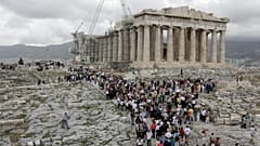 Tourists visit the 2,500-year-old Parthenon Temple on the Acropolis hill, in Athens