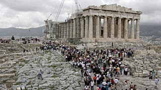Tourists visit the 2,500-year-old Parthenon Temple on the Acropolis hill, in Athens