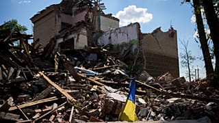 A torn Ukraine flag waves among debris in a school destroyed in a Russian bombing in Bakhmut, eastern Ukraine, Tuesday, May 24, 2022.