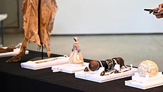 A woman takes pictures of Namibian art pieces from the collection of the Ethnological Museum in Berlin on display