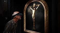 A French painting restorer inspects a 1631 oil on canvas painting by Rembrandt, "The Christ on the Cross" 