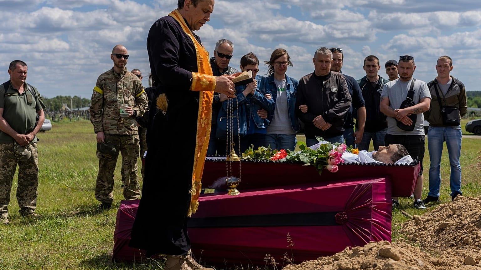 Relatives and friends attend the funeral of Ukrainian serviceman Vitaliy Nejenits in Kharkiv cemetery, eastern Ukraine, Friday, May 27, 2022.