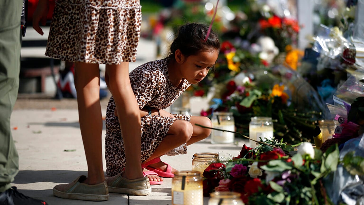A child looks at a memorial site for the victims killed in this week's shooting at Robb Elementary School