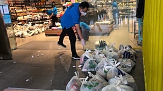 موظف سوبر ماركت يعد أكياس البقالة لخدمة التوصيل إلى المنازل في شنغهاي، الصين