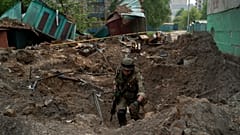 A special task force policeman inspects a site after an airstrike by Russian forces in Lysychansk on 13 May 2022
