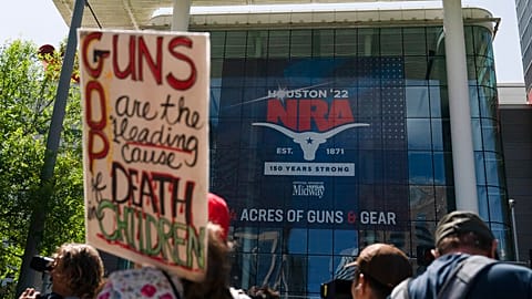 People protest outside the NRA convention.