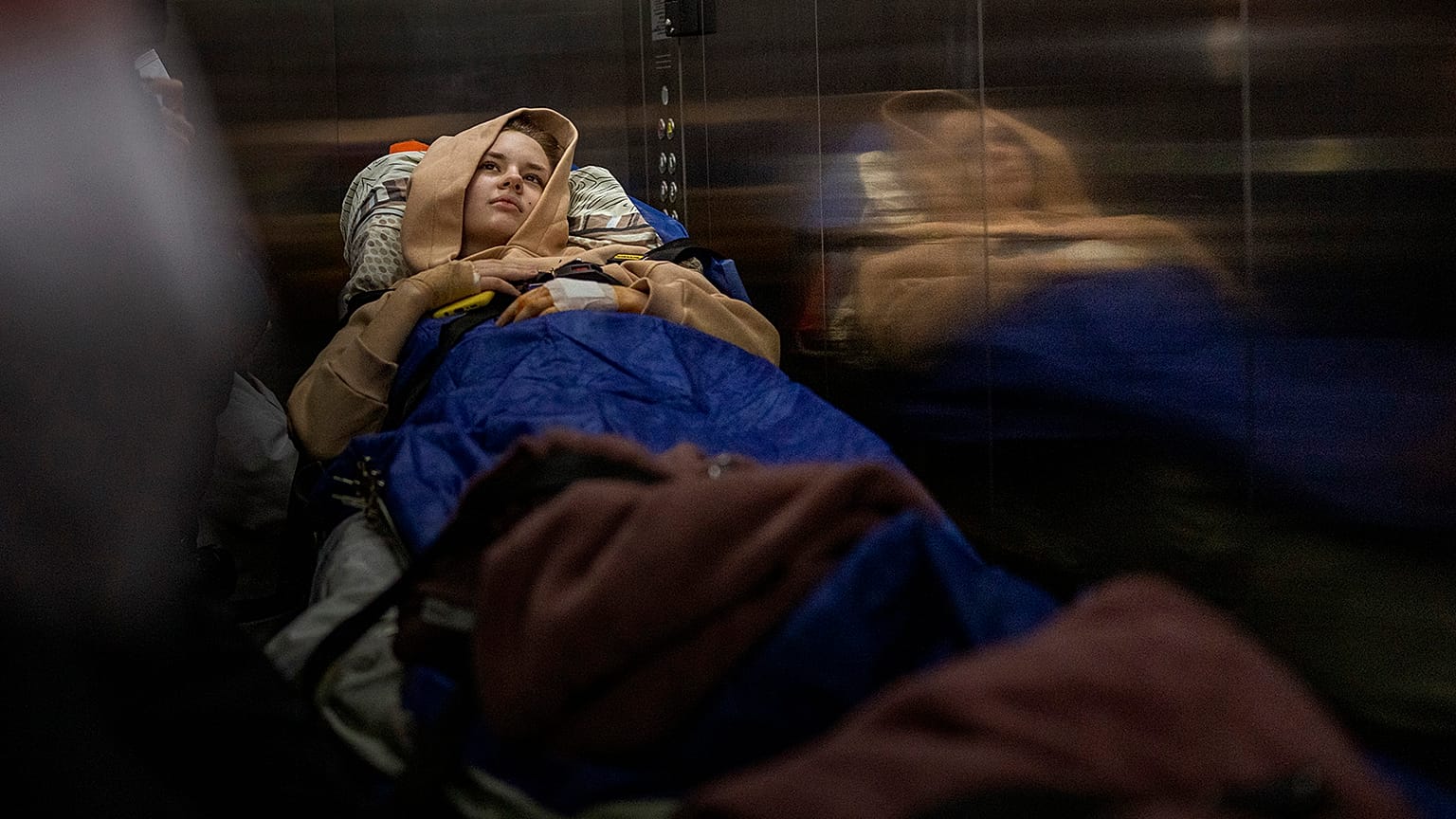 Nastia Kuzik, 21, is carried on a stretcher in a lift while being transported by a medical team to Germany, at a public hospital in Kyiv on 5 May 2022