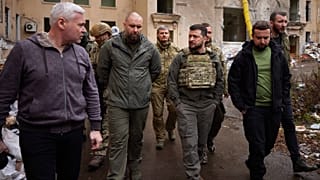 الرئيس الأوكراني فولوديمير زيلينسكي (يمين الوسط) يتحدث مع المسؤولين المحليين أثناء زيارته لمنطقة خاركيف المنكوبة، 29 مايو 2022