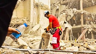 یک نیروی هلال احمر در حال آواربرداری ساختمان متروپل