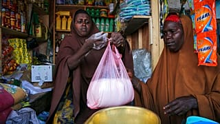 A woman buys wheat flour in Mogadishu, Somali where prices are up 45 per cent since Russia's invasion of Ukraine