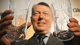 Former UK Home Secretary Alan Johnson holds two pint glasses in London, Thursday, Feb 2010.