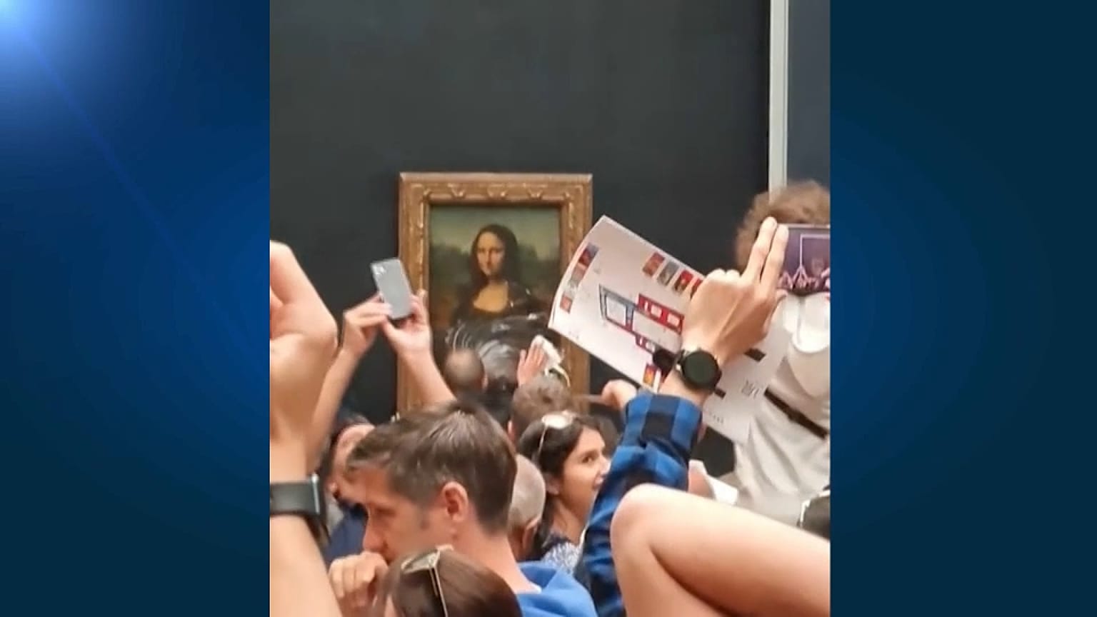 Un empleado del museo del Louvre limpia los restos de una tarta lanzada contra la Gioconda
