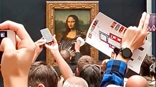 Охранник Лувра вытирает следы торта с защитного стекла на картине "Мона Лиза", 30 мая 2022 г.