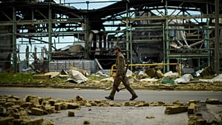 A Ukrainian serviceman walks past a gypsum manufacturing plant destroyed in a Russian bombing in Bakhmut, eastern Ukraine on 28 May 2022
