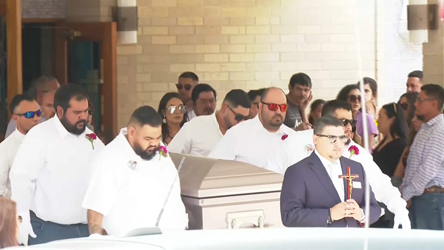 El feretro de Amerie con los portadores llevando su flor preferida
