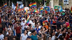 إسرائيليون يلوحون بالأعلام ويحملون لافتات خلال موكب المثليين السنوي في القدس. 2019/06/06