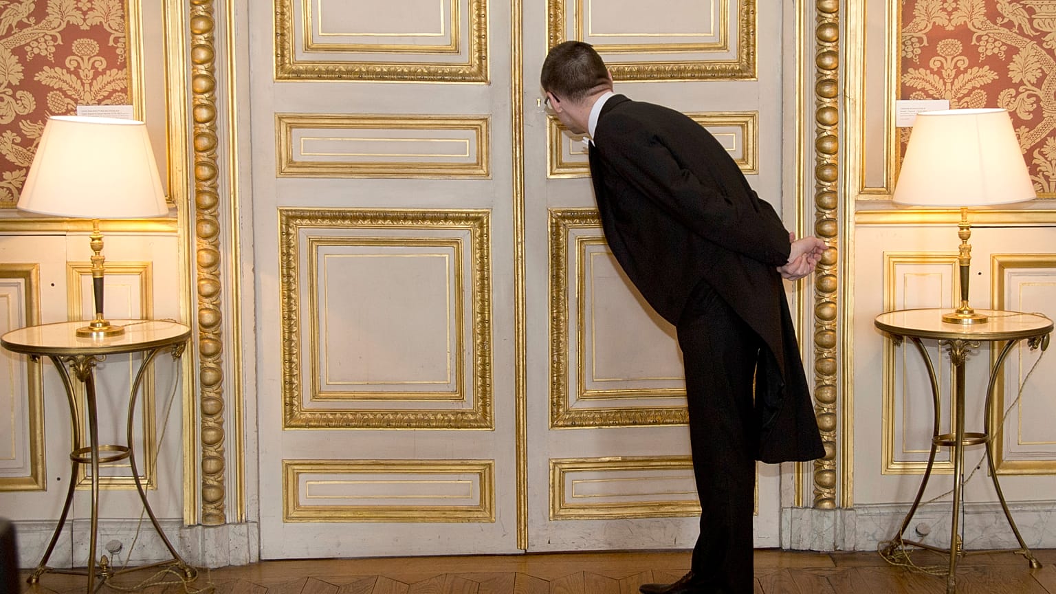A usher looks through the key hole at the French foreign ministry in Paris, Friday March 4, 2016
