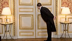 A usher looks through the key hole at the French foreign ministry in Paris, Friday March 4, 2016