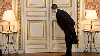 A usher looks through the key hole at the French foreign ministry in Paris, Friday March 4, 2016