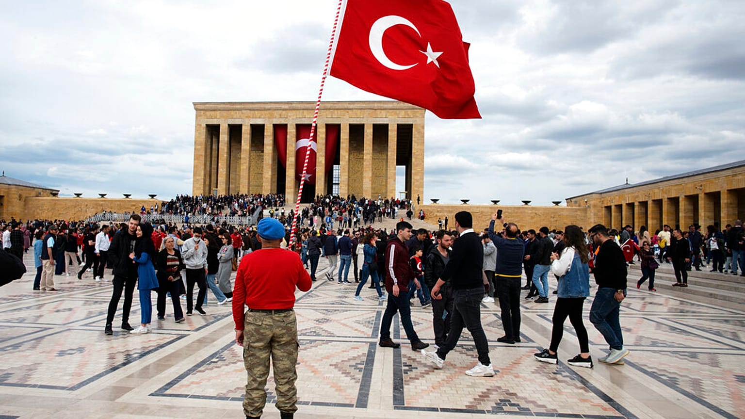A man stands with a national flag as thousands of people visit the mausoleum of Mustafa Kemal Ataturk, the founder of modern Turkey, Thursday, May 19, 2022. 