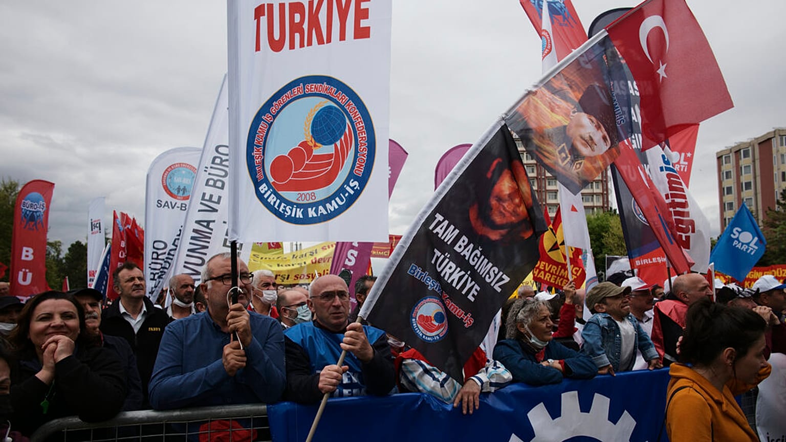 Tausende von Menschen schwenken Fahnen und Transparente während einer Mai-Demonstration in Ankara, Türkei, Sonntag, 1. Mai 2022