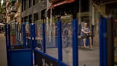 Eine Frau sitzt auf einem Tisch vor einer geschlossenen Bar während der Pandemie in Barcelona, 01.06.2020