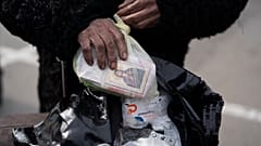 Эвакуированная из Мариуполя в Запорожье держит в руках пакет с медикаментами и иконой. Май, 2022 года