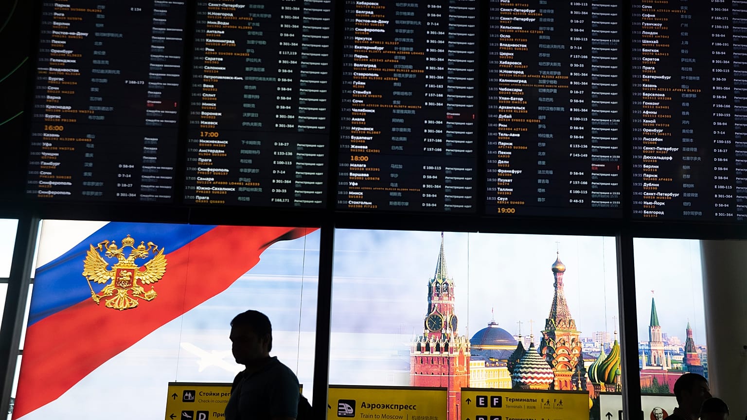 Viajeros pasan ante la pantalla de salidas del aeropuerto moscovita de Sheremetyevo 