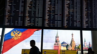 Viajeros pasan ante la pantalla de salidas del aeropuerto moscovita de Sheremetyevo