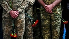 Ukrainian servicemen hold flowers during a funeral service for Army Col. Oleksander Makhachek in Zhytomyr on 3 May 2022