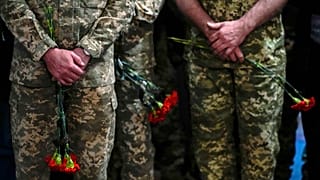 Ukrainian servicemen hold flowers during a funeral service for Army Col. Oleksander Makhachek in Zhytomyr on 3 May 2022