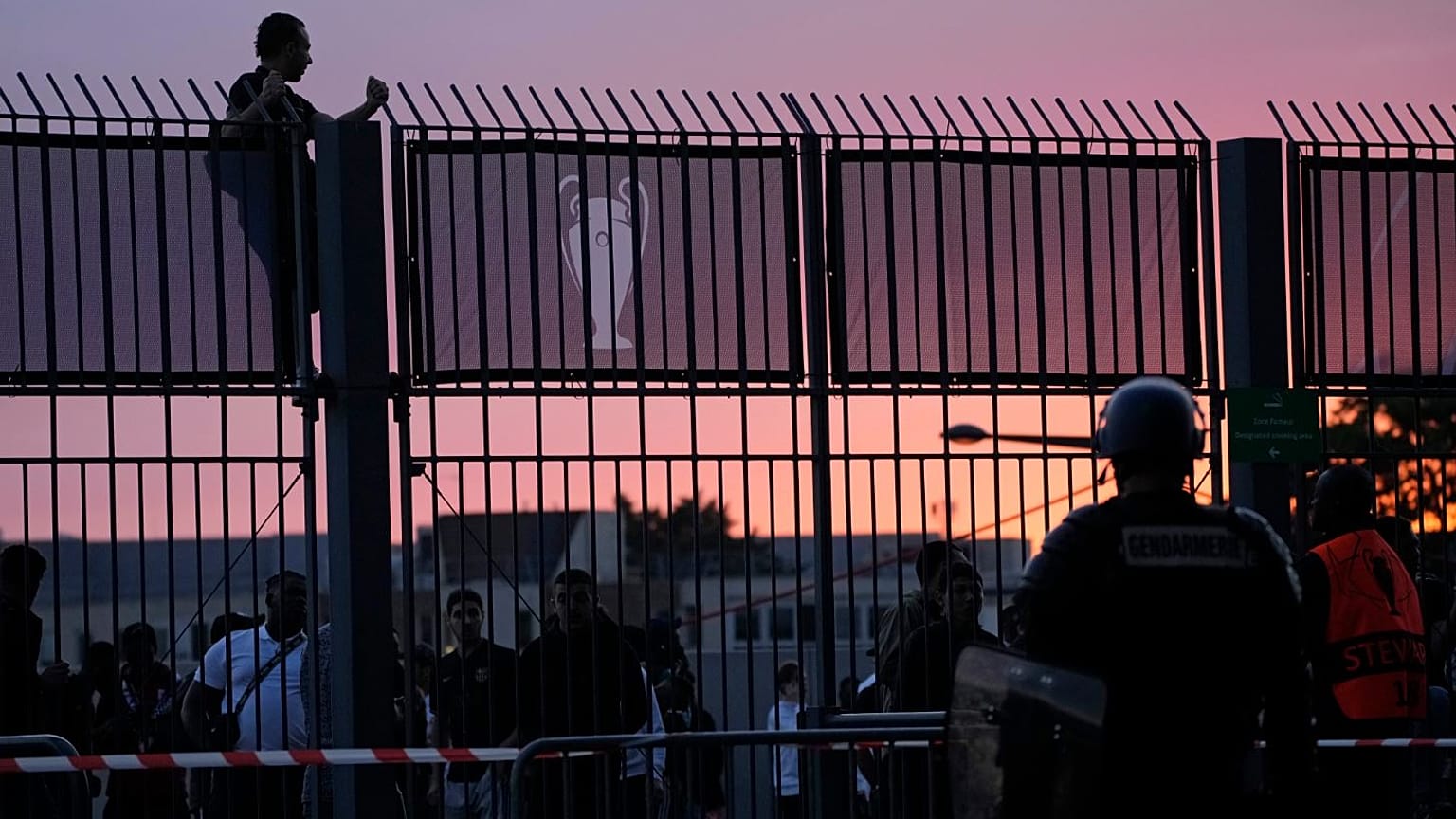 A fan stands on the fence in front of the Stade de France prior the Champions League final.