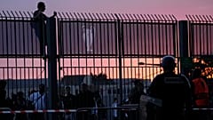 A fan stands on the fence in front of the Stade de France prior the Champions League final.