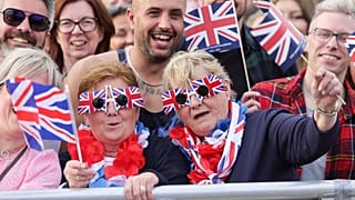 Miembros del público observan el concierto del Jubileo de Platino que tiene lugar frente al Palacio de Buckingham, Londres, el sábado 4 de junio de 2022,