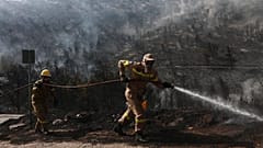 Feuerwehrleute während eines Waldbrandes im Vorort Voula im Süden Athens