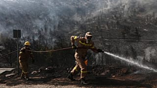 Feuerwehrleute während eines Waldbrandes im Vorort Voula im Süden Athens