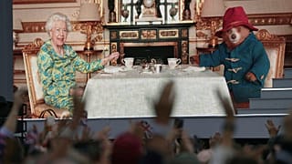 The crowd watch a film of Queen Elizabeth II having tea with Paddington Bear on a big screen at the Platinum Jubilee concert taking place in front of Buckingham Palace, London