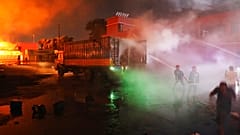 Des pompiers luttent contre un incendie dans l'entrepôt de Sitakunda au Bangladesh, dans la nuit de samedi à dimanche