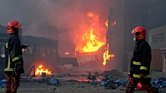 يصل رجال الإطفاء إلى الموقع بعد اندلاع حريق في منشأة لتخزين الحاويات في بنغلادش- 5 يونيو 2022