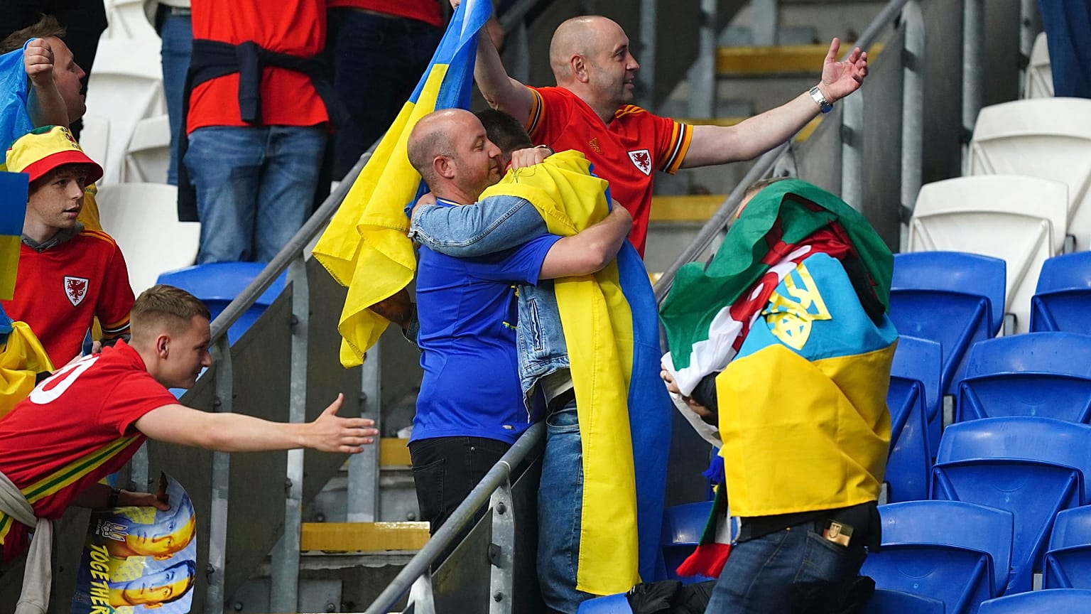 Accolade entre fans gallois et ukrainiens au Cardiff City Stadium, après la défaite 1-0 de l'Ukraine, synonyme d'élimination dans la course à la qualification au mondial 2022.