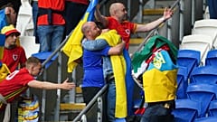 Accolade entre fans gallois et ukrainiens au Cardiff City Stadium, après la défaite 1-0 de l'Ukraine, synonyme d'élimination dans la course à la qualification au mondial 2022.